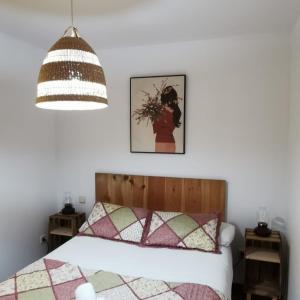a bedroom with a bed and a pendant light at CASITAS PINILLA DEL VALLE in Pinilla del Valle