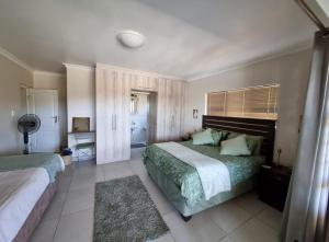 a bedroom with two beds and a window at 25 On Rooiels in Hartenbos