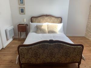 GÎte des Ruches - Peaceful & Homely with shared pool في Chives: سرير في غرفة نوم مع أريكة وطاولة