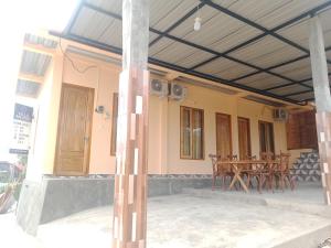 une maison avec une terrasse couverte dotée de tables et de chaises dans l'établissement An Nur Homestay Bira Beach, à Bira
