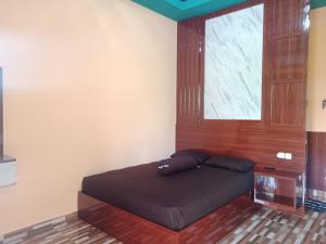 uma cama num quarto com uma janela e uma cama sidx sidx em An Nur Homestay Bira Beach em Bira