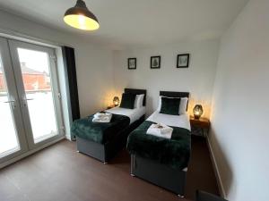 1 dormitorio con 2 camas y ventana en Stylish 2 Bed Riverside Flat, Single or Kingsize beds, Free Parking en Southampton