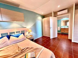 a bedroom with a large bed and a bathroom at Camping Village Tuscia Tirrenica in Tarquinia