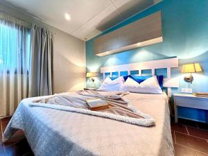 a bedroom with a large bed with a blue wall at Camping Village Tuscia Tirrenica in Tarquinia