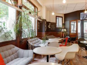 un restaurant avec des tables, des chaises et des plantes dans l'établissement ibis Angers Centre Chateau, à Angers