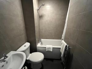 a bathroom with a toilet and a sink and a tub at Stylish 2 Bed Riverside Flat, Single or Kingsize beds, Free Parking in Southampton