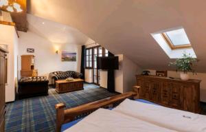 a attic room with a bed and a couch at Vitushöhle & Vitusfort Urlaub im Allgäu - Ferienwohnungen & Themenzimmer in Hopfen am See in Füssen