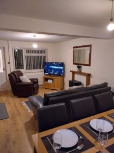 a living room with a couch and a tv at Templecombe in Temple Combe