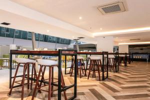 um bar num restaurante com bancos de bar em Days Hotel & Suites by Wyndham Fraser Business Park KL em Kuala Lumpur