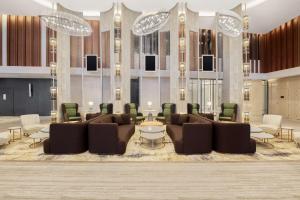 a lobby with couches and a table and chairs at Radisson Blu Hotel Riyadh Convention and Exhibition Center in Riyadh +257 photos