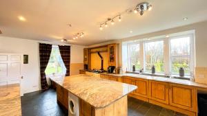 cocina grande con armarios de madera y encimera en Pentland Farm House en Kirknewton
