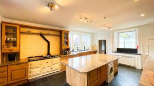 una grande cucina con armadi in legno e una grande isola di Pentland Farm House a Kirknewton