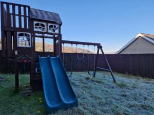 a playground with a slide in a yard at Flat 1, Modern studio apartment, Tynte Hotel, Mountain Ash in Quakers Yard