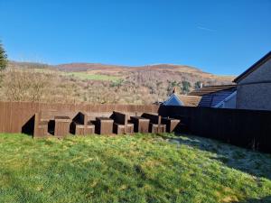 a garden with a bunch of boxes in the grass at Flat 1, Modern studio apartment, Tynte Hotel, Mountain Ash in Quakers Yard