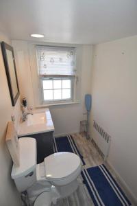 a bathroom with a toilet and a sink and a window at Summer Wind 