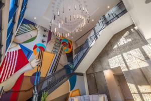 Camera con murale di una donna che suona una fisarmonica di Hyatt Place Gainesville Downtown a Gainesville