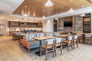 um restaurante com mesas e cadeiras e um bar em Hyatt Place Gainesville Downtown em Gainesville