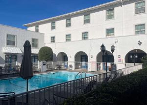 a hotel with a swimming pool in front of a building at Suites Dallas TX Downtown in Dallas