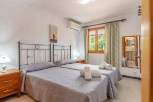 een slaapkamer met twee bedden met handdoeken erop bij Villa Tomeu in Pollença +18 foto's
