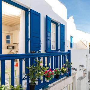 a blue door and some flowers on a balcony at Izabela's House Mykonos Town in Megali Ammos