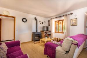 een woonkamer met paarse meubels en een kachel bij Villa Tomeu in Pollença