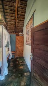 um quarto com uma cama e uma porta de madeira em Kitesurf Tofo House em Praia do Tofo