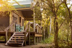 a cabin in the woods with a porch and stairs at Thamo Telele in Maun