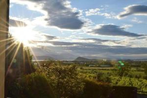 una vista del sol brillando sobre un campo en Casa Vacanze Baccolo, en Polpenazze del Garda