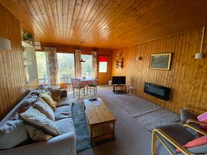 a living room with a couch and a table at Great Glen Holidays - Chalets in Fort William