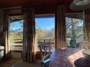 a room with a table and a large window at Great Glen Holidays - Chalets in Fort William