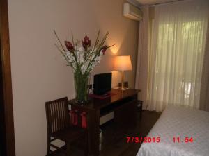 a bedroom with a desk with a vase of flowers on it at Albergo Ponte Vecchio in Cernobbio