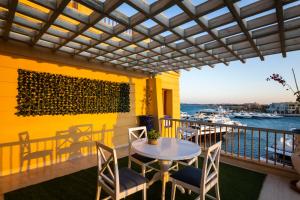 a patio with a table and chairs on a balcony at El Gouna Elite Worldwide Private Residences, Sea & Garden View - Hurghada, Egypt in Hurghada