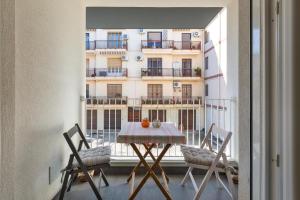 una mesa y sillas en un balcón con un edificio en Conteduca Apartment by BarbarHouse, en Fasano