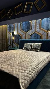 een slaapkamer met een groot bed met een blauwe muur bij LUX 114 APARTMENT in Košice