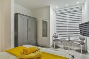 a bedroom with a bed and two chairs and a window at The Apartment - Ground Floor - Luxury for up to 4 guests near Open Air Theatre and North Bay in Scarborough +3 photos