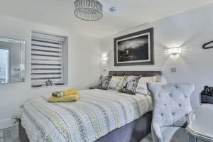 a bedroom with a bed and a chair at The Apartment - Ground Floor - Luxury for up to 4 guests near Open Air Theatre and North Bay in Scarborough