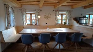 a dining room with a wooden table and blue chairs at Chalet Schmuckkastal BAYW100 in Kollnburg