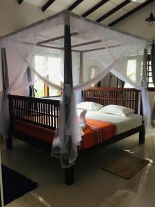 Bett mit Baldachin in einem Zimmer in der Unterkunft Sathis villa in Ambalangoda