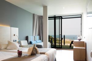 a bedroom with two beds and a view of the ocean at Hotel Astuy in Isla