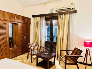 a bedroom with a bed and a chair and a table at Waterfront Beach Villa In Baga with Private Pool in Baga