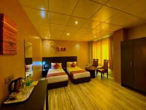 una camera d'albergo con due letti e una scrivania di Ace Prime Hotel a Greater Noida