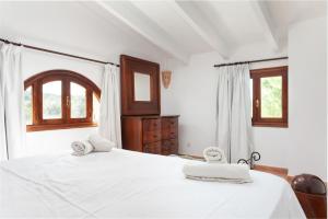 a bedroom with a white bed with towels on it at Finca CASA FINA, POOL, BBQ, WIFI in Felanitx +43 photos