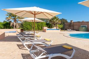 two lounge chairs and an umbrella next to a pool at Finca CASA FINA, POOL, BBQ, WIFI in Felanitx