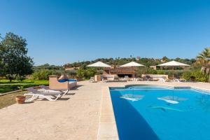 a swimming pool with chairs and umbrellas on a resort at Finca CASA FINA, POOL, BBQ, WIFI in Felanitx