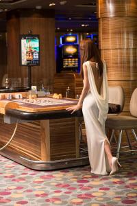 a woman standing at a table in a casino at International Hotel Casino & Tower Suites in Golden Sands