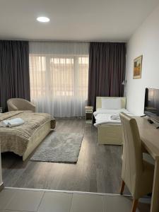 a bedroom with two beds and a desk with a computer at Garni Hotel Hamburg in Zaječar