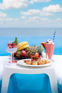 a white table with a plate of fruit and a drink at International Hotel Casino & Tower Suites in Golden Sands