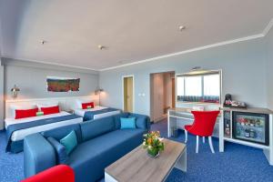 a hotel room with two beds and a blue couch at International Hotel Casino & Tower Suites in Golden Sands