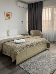 sypialnia z łóżkiem z krzesłem i oknem w obiekcie Garni Hotel Hamburg w mieście Zaječar