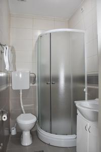 een badkamer met een douche, een toilet en een wastafel bij Garni Hotel Hamburg in Zaječar